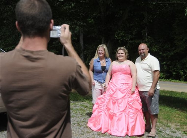 Dade County High School student Delana Blevins, center, is joined by her stepmother, Angela Blevins, left, and her dad, Danny Blevins, as Clint Mitchell takes a photograph Saturday before the prom, in Dade County, Ga. 